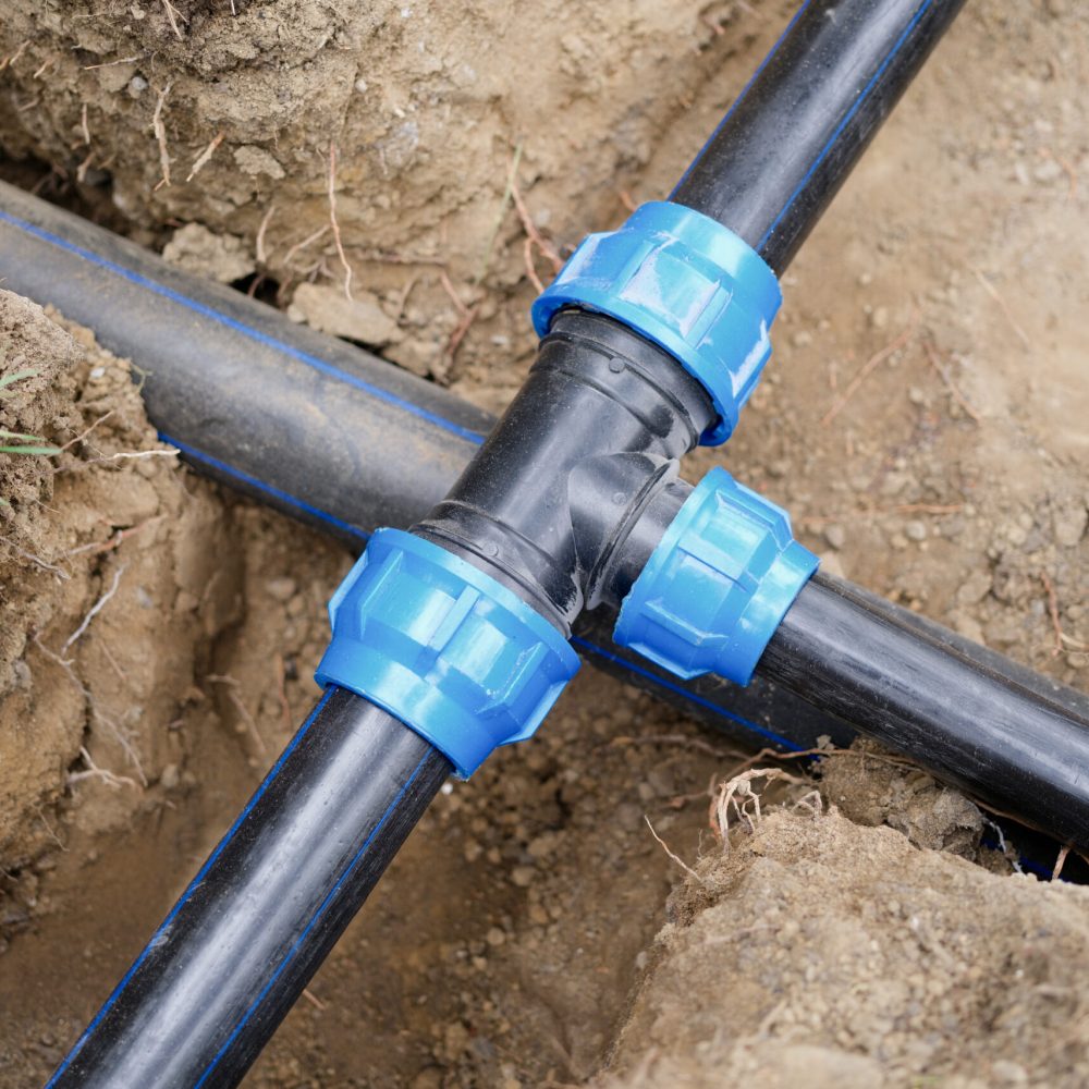 Installed PVC water pipes in trench at construction site. Plumbing system outside the house concept